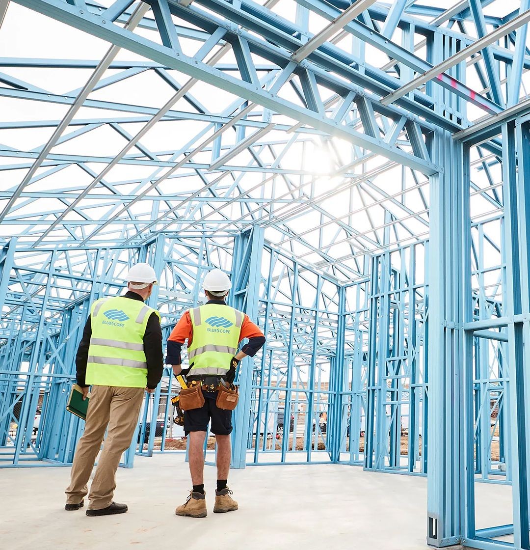 A blue steel truecore frame with bluescope employees at a building site