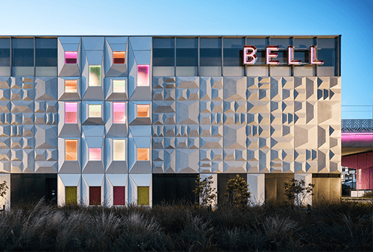 building with a modern, geometric facade featuring repeating patterns of angular shapes