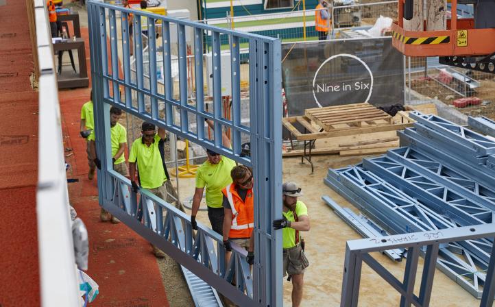 Crews carrying wall framing made from TRUECORE® steel