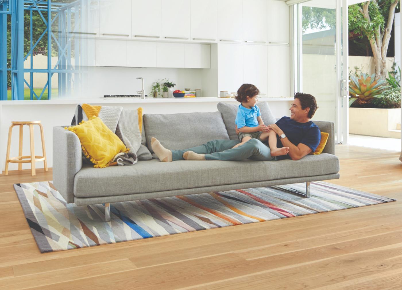 TRUECORE steel QLDbuilder promo_father and son on a grey lounge in a house made from blue steel frames